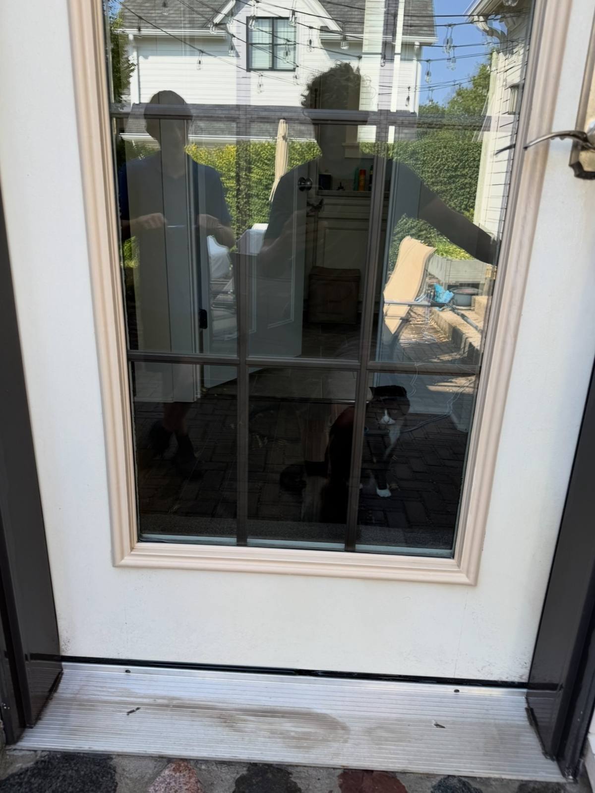 After: the same patio door with the lower panel and threshold washed clean and bright white