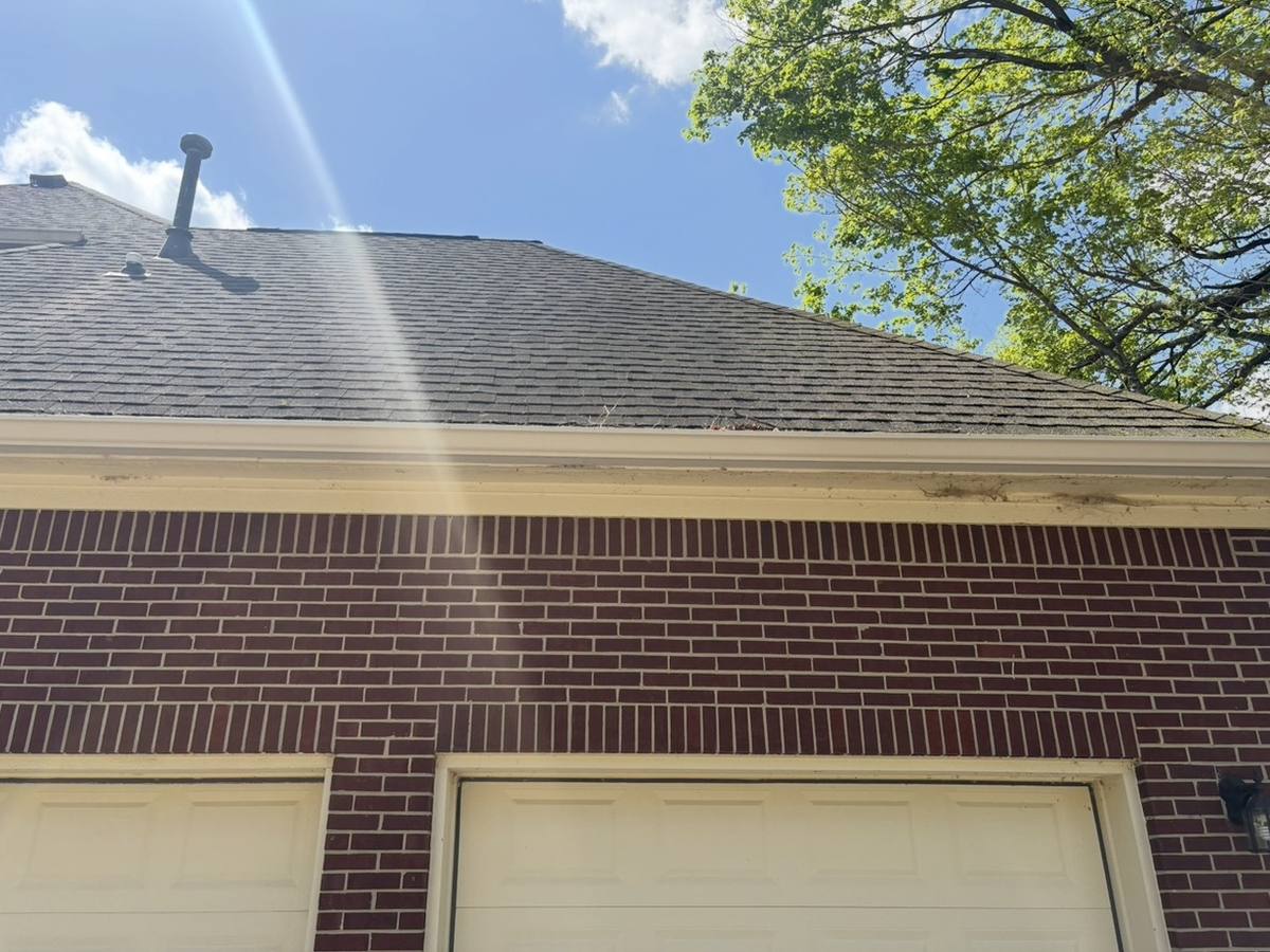 After: the same gutters and fascia brightened to clean white along the roofline